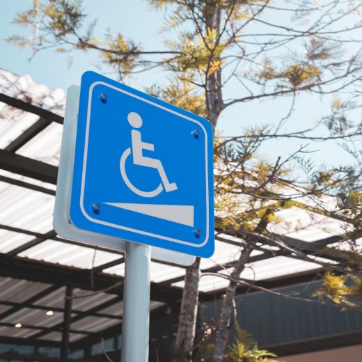 Persona en silla de ruedas accediendo a un edificio con rampa